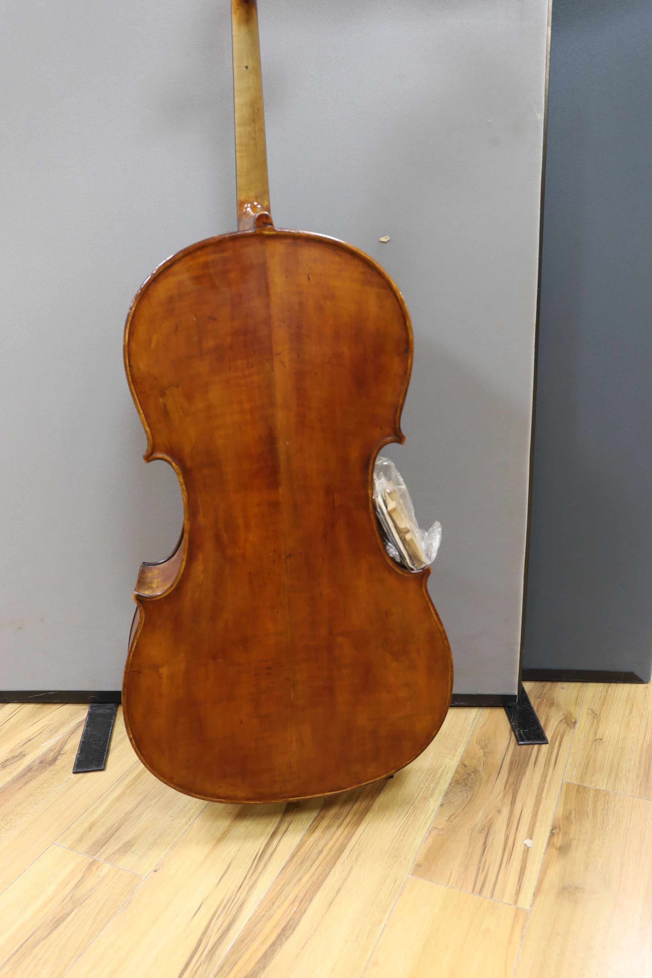A cased early 20th century ‘cello, length of body 75.5cm, with two spare bridges, and spare strings